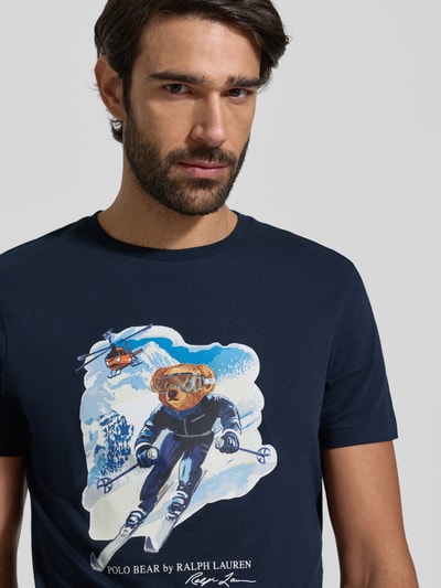 Männermodel trägt T-Shirt mit Label-Print von Polo Ralph Lauren, reine Baumwolle, Slim Fit, dunkelblau, Nahaufnahme Oberkörper.