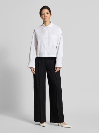 Frauenmodel trägt Weite Hose aus reiner Viskose Modell 'TIANA4' von BOSS mit Nadelstreifen, Allover-Muster, Ganzkörperansicht von vorne.