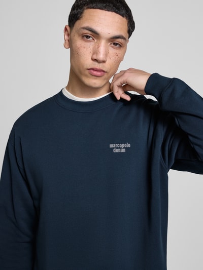 Mannenmodel draagt Regular Fit Sweatshirt uit pure katoen van Marc O'Polo Denim, effen, labelprint, ronde hals, ribboorden, close-up bovenlichaam.