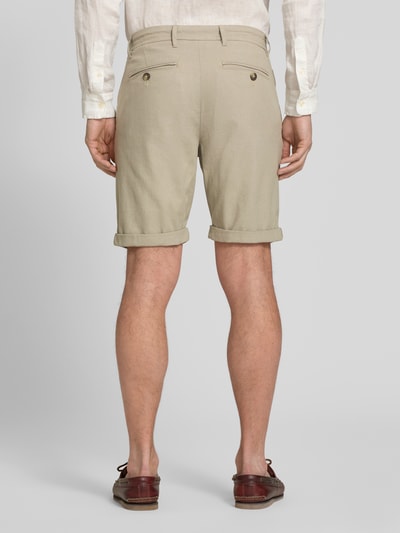 Männermodel trägt Slim Fit Chinoshorts aus Baumwoll-Mix Modell 'LUTON' von SELECTED HOMME in Beige mit feiner Webstruktur, Ganzkörperansicht Rückansicht.
