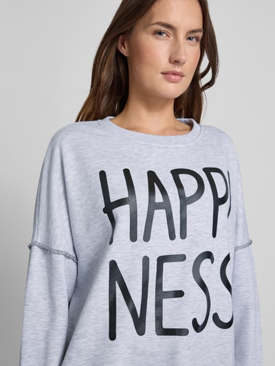 Frauenmodel trägt Sweatshirt mit Statement-Print von miss goodlife, helle Farbe, Reine Baumwolle, Lockerer-Schnitt, Rundhalsausschnitt, Gerippte-Abschlüsse, Nahaufnahme Oberkörper.