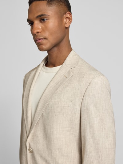 Männermodel trägt Slim Fit 2-Knopf-Sakko mit Viskose-Anteil Modell 'DATI' von CINQUE in hellem Beige, feine Textur, Nahaufnahme Oberkörper. Elastischer Material-Mix mit Reverskragen und Brusttasche.
