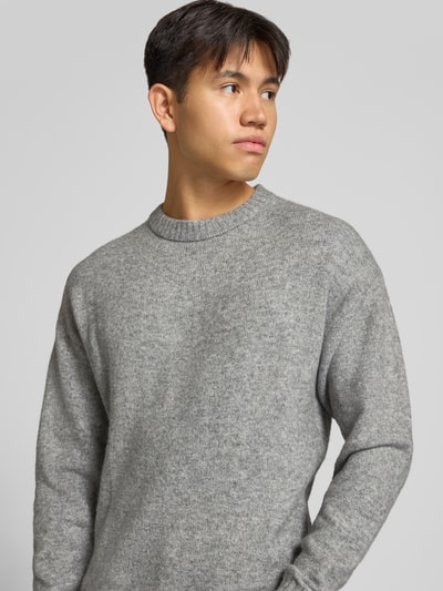 Männermodel trägt grauen Strickpullover mit Rundhalsausschnitt Modell 'SOHO OLLIE' von JACK & JONES, Woll-Materialmix, Nahaufnahme Oberkörper.