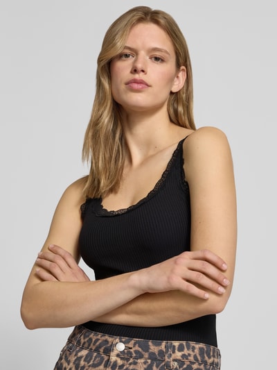 Frauenmodel trägt Slim Fit Tank Top aus Bio-Baumwoll-Mix Modell 'SARA' von Only, schwarz, unifarben, Spitze, U-Ausschnitt, Feinripp, Nahaufnahme Oberkörper.