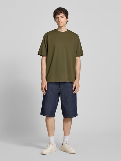 Męski model nosi Oversized T-Shirt Modell 'FISHER' od Blend, czysta bawełna, krój oversize, okrągły dekolt, długość pleców w rozmiarze M: 72 cm, cała sylwetka z przodu.