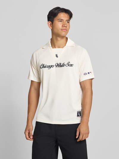 Männermodel trägt Relaxed Fit Poloshirt mit Logo-Stitching von Champion, cremefarben, schwarzer Schriftzug, Polokragen, kurzärmelig, Ganzkörperansicht von vorne, Rückenlänge bei Größe M 70 cm.