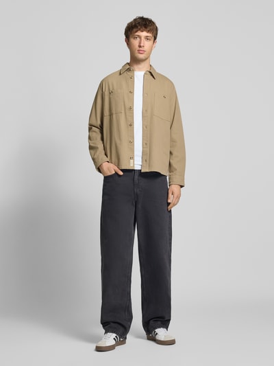 Männermodel trägt Regular Fit Hemdjacke mit Brusttaschen Modell 'DENNY' von Blend, beige, reine Baumwolle, Ganzkörperansicht von vorne