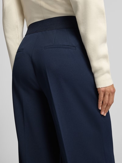 Frauenmodel trägt Culotte mit Bügelfalten von Betty Barclay in Dunkelblau, mit seitlichen Eingrifftaschen, Nahaufnahme Rückansicht.
