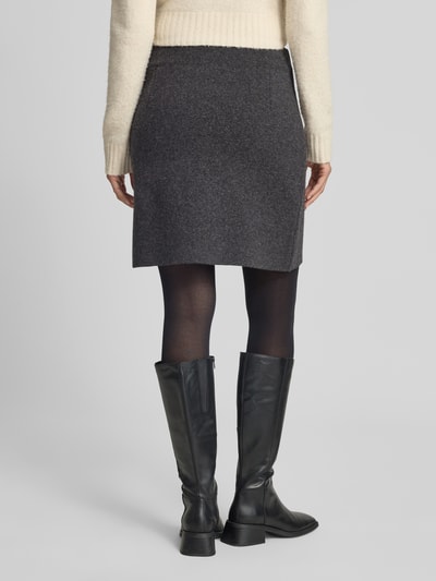 Männermodel trägt Slim Fit Mini-Rock aus Baumwoll-Mix von ARMEDANGELS, dunkles Grau, einfarbig, mittlere Textur, Ganzkörperansicht Rückansicht
