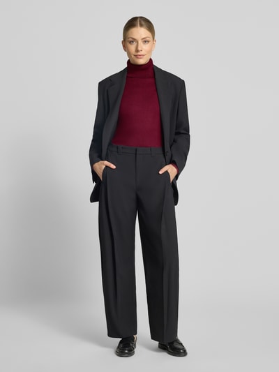 Frauenmodel trägt Slim Fit Strickpullover aus Viskose-Mix Modell 'IHLULS' von ICHI in Dunkelrot, kombiniert mit schwarzer Anzughose, Damen Strickpullover, Rollkragen, elastische Abschlüsse, Ganzkörperansicht von vorne.