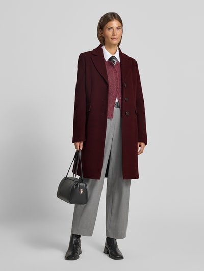 Vrouwenmodel draagt Mantel aus Woll-Mix mit Reverskragen und Pattentaschen van FUCHS SCHMITT in bordeauxrood, straight fit, zwarte knoopsluiting, grijze broek, zwarte laarzen en zwarte handtas, mix van wol en kasjmier, reverskraag, klepzakken, ruglengte maat 36: 95 cm, schouderbreedte: 42 cm, borstwijdte: 48 cm, mouwlengte: 66 cm, volledige vooraanzicht.