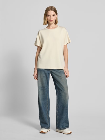Kobiece model prezentuje damski t-shirt z mieszanki materiałów z domieszką modalu, krój relaxed fit, okrągły dekolt, model 'BANU' od Soyaconcept, kolor jasny, gładka tekstura, widok całej sylwetki z przodu.