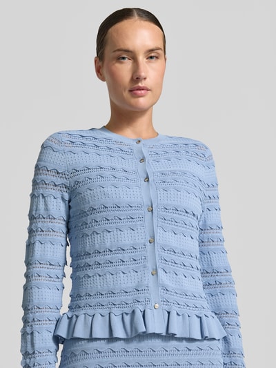 Modelka nosi Regular Fit Cardigan aus Viskose-Mix Model 'Avria' od Ted Baker, imitacja dzianiny, obszycie falbanami, okrągły dekolt, pełna listwa guzikowa, kolor jasnoniebieski, Długość tyłu w rozmiarze 36: 49 cm, Długość rękawów w rozmiarze 36: 61 cm, mieszanka wiskozy, widoczna tekstura i ażurowy wzór, ujęcie z przodu, zbliżenie na górną część ciała.