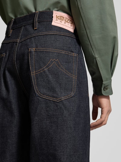 Männermodel trägt Wide Fit Jeans aus reiner Baumwolle von Kenzo, dunkle Denimfarbe, Kontrastnähte, 5-Pocket-Design, Detailaufnahme Rückansicht.