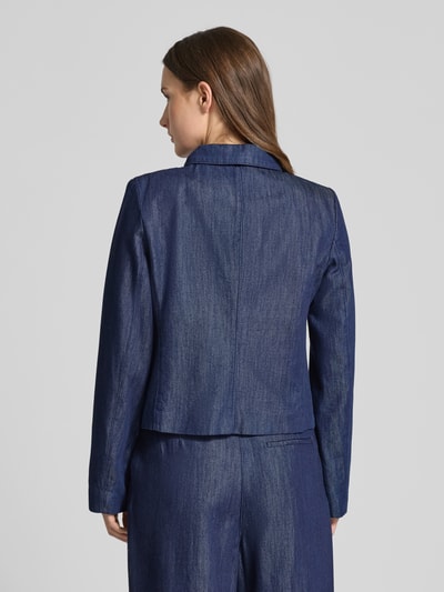 Vrouwenmodel draagt Regular Fit Blazer in Denim-Optik mit Lyocell-Anteil van Christian Berg Woman Selection, blauw, licht getailleerd, katoenmix, lange mouwen, overhemdkraag, decoratieve strik, knoopsluiting, ruglengte 51 cm, borstwijdte 48 cm, mouwlengte 63 cm. Volledige lichaam achteraanzicht.