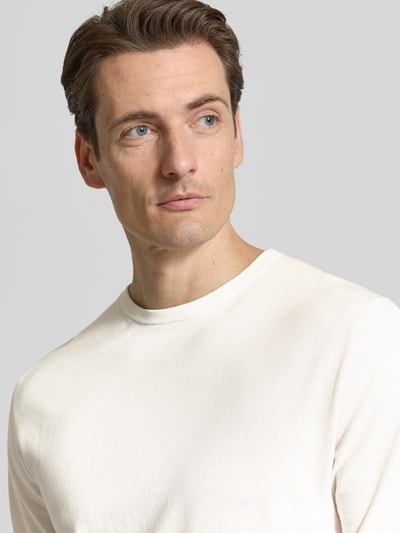 Mannelijk model draagt Regular Fit Strick-Shirt aus Bio-Baumwolle Modell 'TORINO' van Selected Homme in effen kleuren, fijngebreid, ronde hals, korte mouw, biologisch katoen, nahaufnahme bovenlichaam.