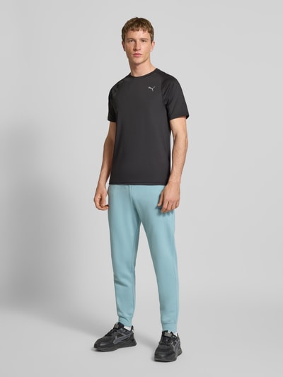 Männermodel trägt Sweatpants mit elastischem Bund von PUMA PERFORMANCE aus Baumwoll-Mix, Lockerer-Schnitt, Label-Stitching, französische Eingrifftaschen, Herren, Ganzkörperansicht von vorne.