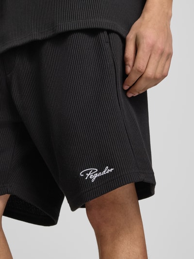 Männermodel trägt Shorts mit Logo-Stitching und elastischem Bund von Pegador aus Reine Baumwolle im Feinripp, Nahaufnahme Oberschenkel.