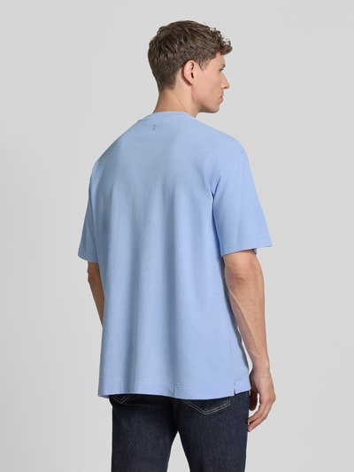 Männermodel trägt hellblaues Relaxed Fit T-Shirt aus reiner Bio-Baumwolle Modell 'MAARKOS WAFFLE' von Armedangels mit Waffle-Struktur, unifarben, Rundhals, kurzarm, Logo-Stitching und Seitenschlitzen, Feinstrick-Material, Ganzkörperansicht Rückansicht.