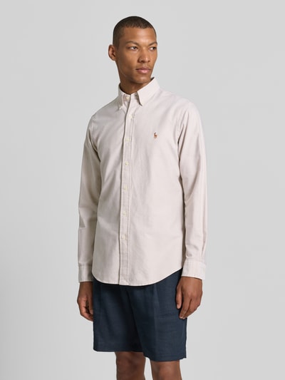 Männermodel trägt Regular Fit Freizeithemd aus reiner Baumwolle von Polo Ralph Lauren in Beige, glatte Textur, Ganzkörperansicht von vorne.