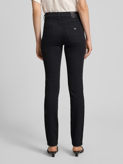 Frauenmodel trägt Slim Fit Jeans mit Eingrifftaschen von Emporio Armani in dunklem Blau, Baumwoll-Elasthan-Mix, Ganzkörperansicht Rückansicht.
