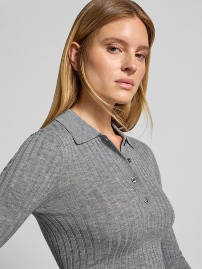 Vrouwenmodel draagt Henley-Shirt aus Wolle van Style Icon Collection in grijs, riblook, polokraag, skinny fit, puur katoen, tricotlook, met lange mouwen, detailopname bovenlichaam.