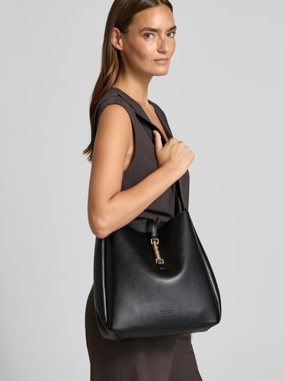 Frauenmodel trägt Crossbody Bag in Leder-Optik Modell 'LOVIISA' von Seidenfelt, schwarz, mit Trageriemen, Hauptfach, Magnetverschluss, Ganzkörperansicht von vorne. Breite 30 cm, Länge 30 cm, Tiefe 12 cm, Schulterriemenlänge 60 cm.