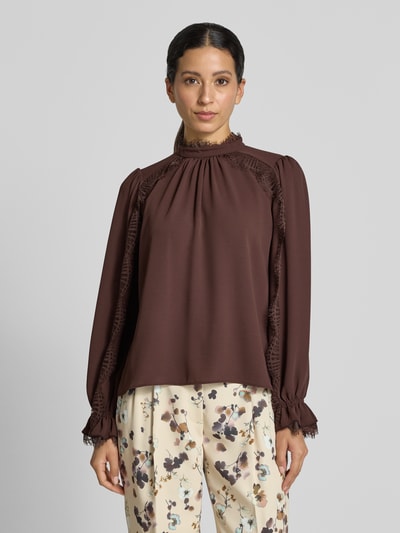 Frauenmodel trägt Regular Fit Bluse mit Spitzenbesatz von Marc Cain in Braun, Chiffon, Stehkragen, lange Ärmel, Ganzkörperansicht von vorne.