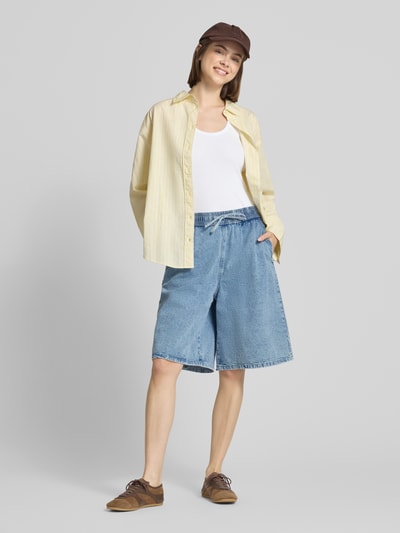 Frauenmodel trägt Jeansshorts mit weitem Bein Modell 'SIGNE' von Noisy May aus reiner Baumwolle, hellblau, elastischer Bund, Ganzkörperansicht von vorne.