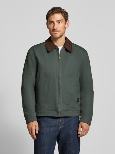 Männermodel trägt Regular Fit Jacke aus reiner Baumwolle von MCNEAL in Dunkelgrün mit Umlegekragen, aufgesetzten Eingrifftaschen, Ganzkörperansicht von vorne. Rückenlänge, Schulterbreite, Brustweite und Ärmellänge laut Größe M.