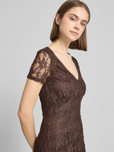 Frauenmodel trägt Slim Fit Minikleid aus Spitze Modell 'ALBINA' von Only in Braun mit V-Ausschnitt, Spitzenmuster, kurzarm, Nahaufnahme Oberkörper.