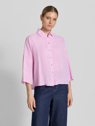 Frauenmodel trägt Leinenbluse mit überschnittenen Schultern von Christian Berg Woman in Rosa, lockerer Schnitt, 3/4-Arm, Kentkragen, Knopfleiste, reine Leinenstruktur, Ganzkörperansicht von vorne.