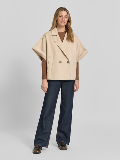 Frauenmodel trägt Regular Fit Kurzmantel aus reiner Schurwolle Modell 'NEO' von Weekend Max Mara, Optik: Unifarben, Materialverarbeitung: gebürstet, Reverskragen, doppelter 1-Knopf-Verschluss, Kurzarm mit Umschlag, seitliche Leistentaschen, Farbe Beige, Textur weich, Ganzkörperansicht von vorne.