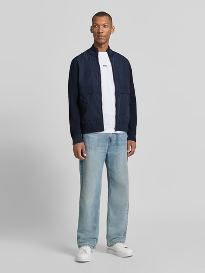 Männermodel trägt Regular Fit Strickjacke aus Baumwoll-Mix Modell 'Kobello' von BOSS Orange, blaue Farbe, Ganzkörperansicht von vorne.