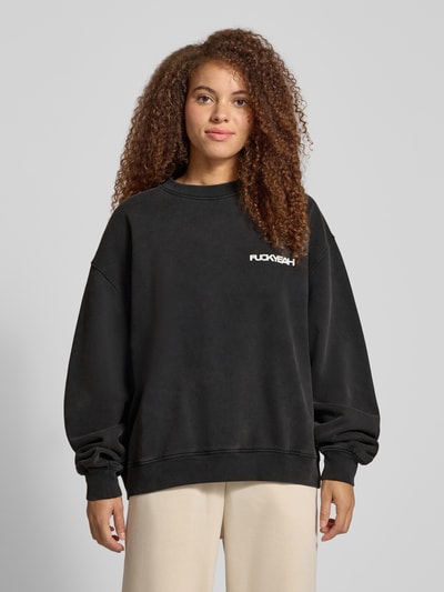 Frauenmodel trägt Oversized Sweatshirt mit Statement-Print von Karo Kauer, reine Baumwolle, gerippte Abschlüsse, Rundhalsausschnitt, Ganzkörperansicht von vorne.