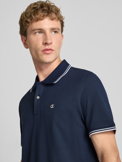 Männermodel draagt Slim Fit Poloshirt met labelstitching van CHAMPION, puur katoen, knoopsluiting, donkerblauw, ruglengte maat M 73 cm, Nahaufnahme Oberkörper