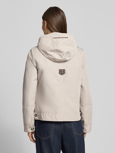 Männermodel trägt Jacke mit Kapuze und Reißverschlusstaschen von Gil Bret, krój regular fit, beżowy, gładka tekstura, długość tyłu w rozmiarze 36: 59 cm, szerokość ramion w rozmiarze 36: 40 cm, szerokość klatki piersiowej w rozmiarze 36: 51 cm, długość rękawa w rozmiarze 36: 63 cm, widok całej sylwetki z tyłu