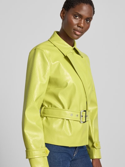 Frauenmodel trägt Jacke mit Gürtel und Ärmelriegeln von Marc Cain in gelb, strukturierte Oberfläche, Regular Fit, Nahaufnahme Oberkörper. Rückenlänge, Schulterbreite, Brustweite und Ärmellänge bei Größe 36: 58 cm, 40 cm, 48 cm, 61 cm.