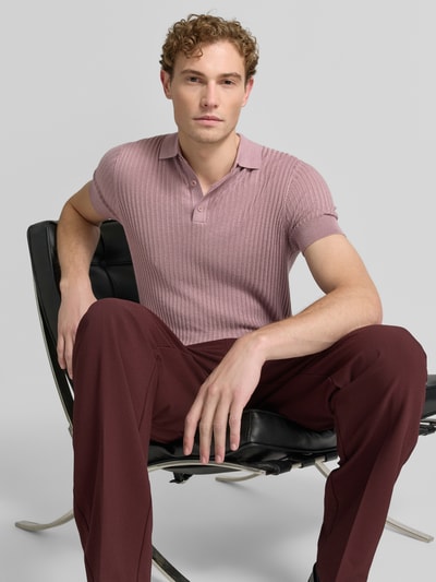 Männermodel trägt Slim Fit Poloshirt aus Viskose-Mix mit Leinen-Anteil von Antony Morato, rosa Strick-Optik, Ganzkörperansicht von vorne, Rückenlänge bei Größe M 70 cm.