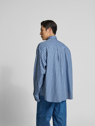 Männermodel trägt Relaxed Fit Freizeithemd aus Baumwolle von VETEMENTS, blau kariert, Langärmlig, Rückenlänge 84 cm, Ganzkörperansicht Rückansicht.