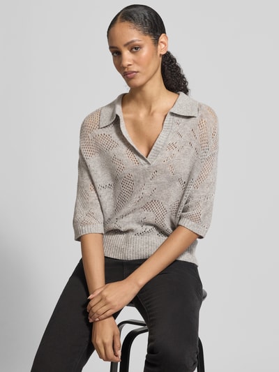 Modelka nosi Relaxed Fit Pullover aus Escorial Woll-Mix mit Kaschmir-Anteil von HERZENS, kolor jasnoszary, dzianina z ażurowym wzorem, półrękawy, kołnierzyk, głęboki dekolt V, elastyczne wykończenia, długość tyłu 55 cm, długość rękawa 23 cm, widok całej sylwetki z przodu.