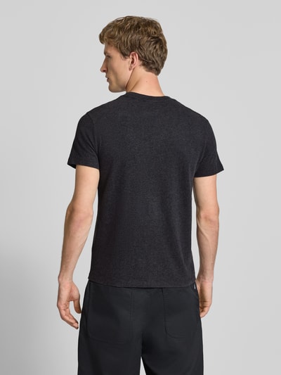 Männermodel trägt Regular Fit T-Shirt mit Logo-Stitching von Superdry aus reiner Baumwolle, Rundhalsausschnitt, Rückenansicht Ganzkörperansicht.