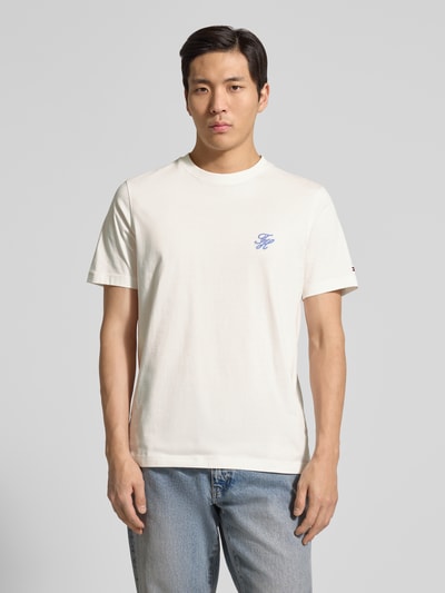 Männermodel trägt Regular Fit T-Shirt aus reiner Baumwolle von Tommy Hilfiger in Unifarbe mit Logo-Stitching, Ganzkörperansicht von vorne.