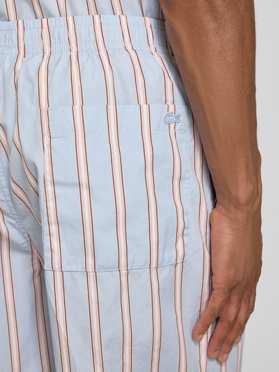 Mężczyznamodel nosi Relaxed Fit Sweatshorts aus reiner Baumwolle von Lacoste, niebiesko-białe, pionowe paski, aplikacja logo, popelina, zbliżenie tylna część.