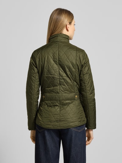 Frauenmodel trägt Regular Fit Steppjacke mit Stehkragen Modell 'FLYWEIGHT' von Barbour in Olivgrün, gesteppte Textur, Ganzkörperansicht Rückansicht.