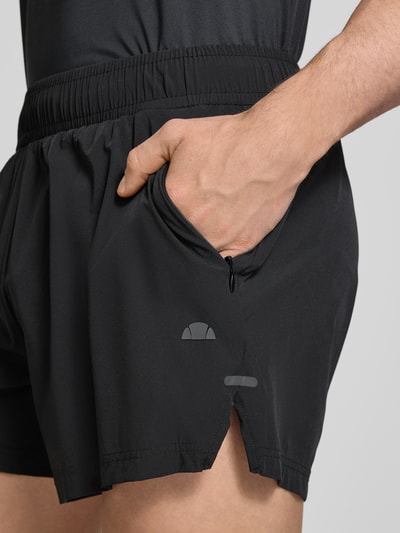 Männermodel trägt Shorts mit elastischem Bund Modell 'ERUDITO' von Ellesse, schwarzer Material-Mix mit Stretch-Anteil, Nahaufnahme Oberschenkel. Regular-Fit, Bundweite bei Größe M: 39 cm, Innenbeinlänge: 12 cm.