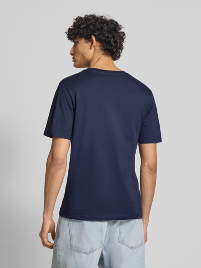 Männermodel trägt Regular Fit T-Shirt aus reiner Baumwolle Modell 'COLE' von Jack & Jones in Dunkelblau, Rückenlänge 70 cm, Ganzkörperansicht Rückansicht.