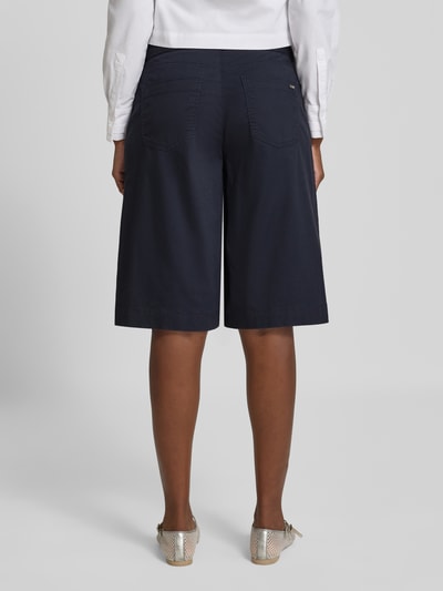 Vrouwenmodel draagt donkerblauwe bermuda met riem, mix van katoen en lyocell, tailored fit, steekzakken, Model 'Liv' van TONI, binnenbeenlengte maat 36: 34 cm, bandwijdte maat 36: 41 cm, volledige lichaamsaanzicht achterkant.