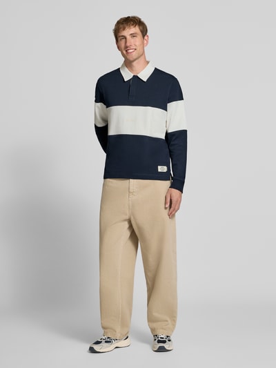 Männermodel trägt Regular Fit Poloshirt mit Label-Stitching Modell 'FREDERIKSBERG' von JACK & JONES, Colour-Blocking, Ganzkörperansicht von vorne, Baumwolle