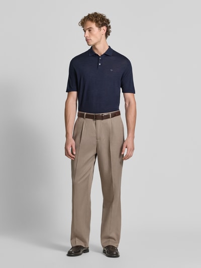 Męski model nosi Regular Fit Poloshirt aus reiner Baumwolle in Strick-Optik von Fynch-Hatton w granatowym kolorze, imitacja dzianiny, krój regular fit, kołnierzyk polo, z krótkim rękawem, Długość tyłu w rozmiarze M: 67 cm, całkowity widok z przodu.